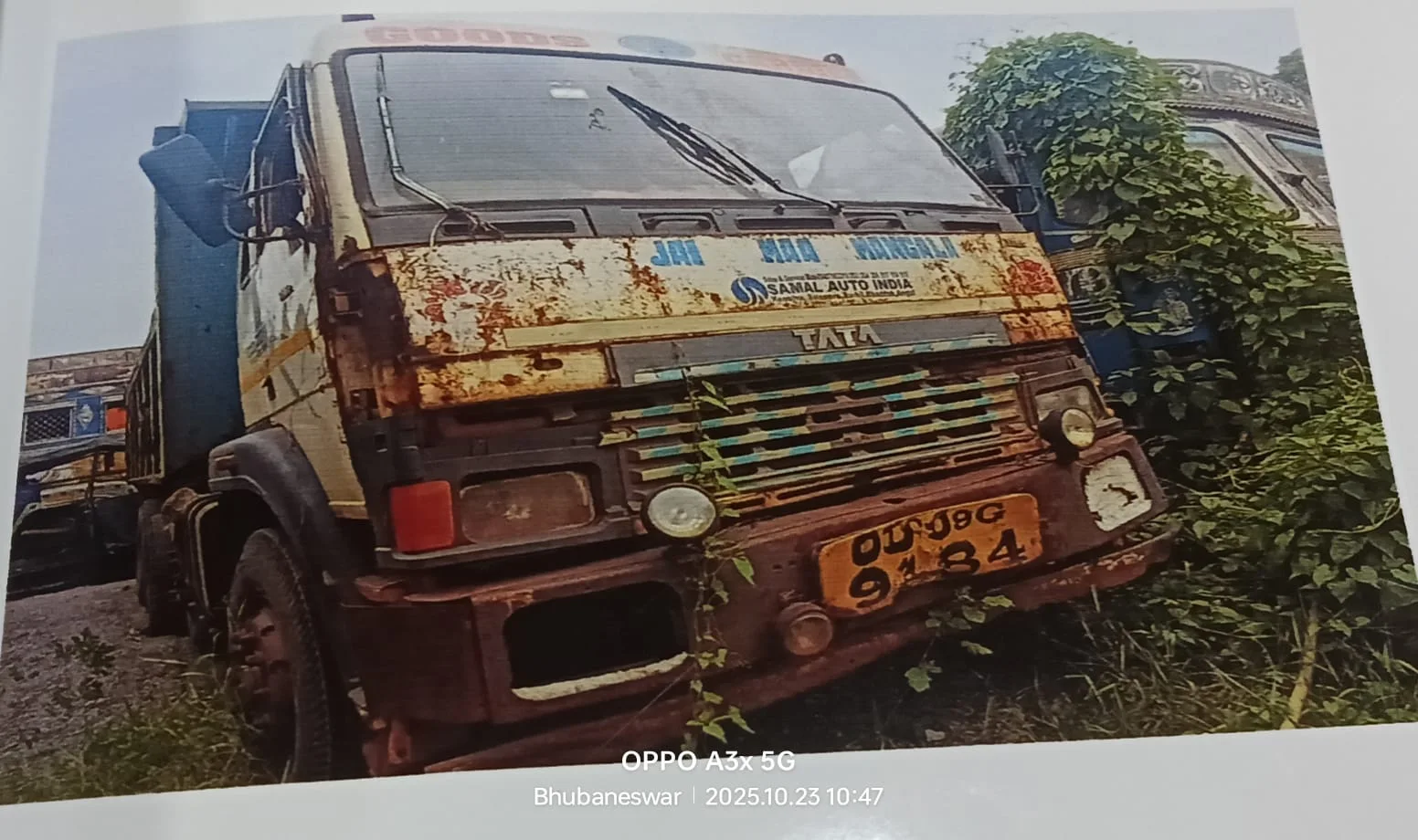 Seized TATA truck with registration OU-09G-9184, located in Kulad, Angul. The vehicle shows signs of heavy rust, damage to the front bumper, and overall poor condition. It is being offered for auction as a secured asset.
